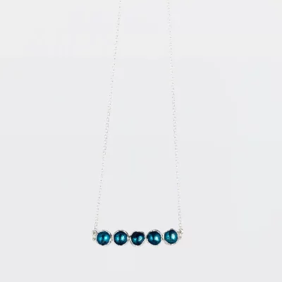 Detalle de colgante Cuncas en plata con cinco piezas circulares esmaltadas en azul, joya artesanal.