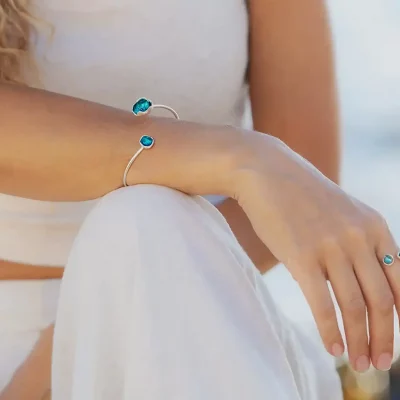 Modelo con Pulsera Cuncas en plata abierta con dos círculos esmaltados en azul vista frontal y anillo